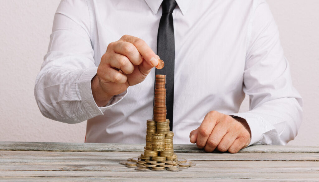 Business man building stack of money
