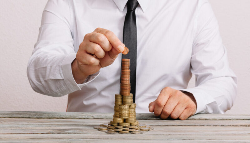 Business man building stack of money Business man building stack of money